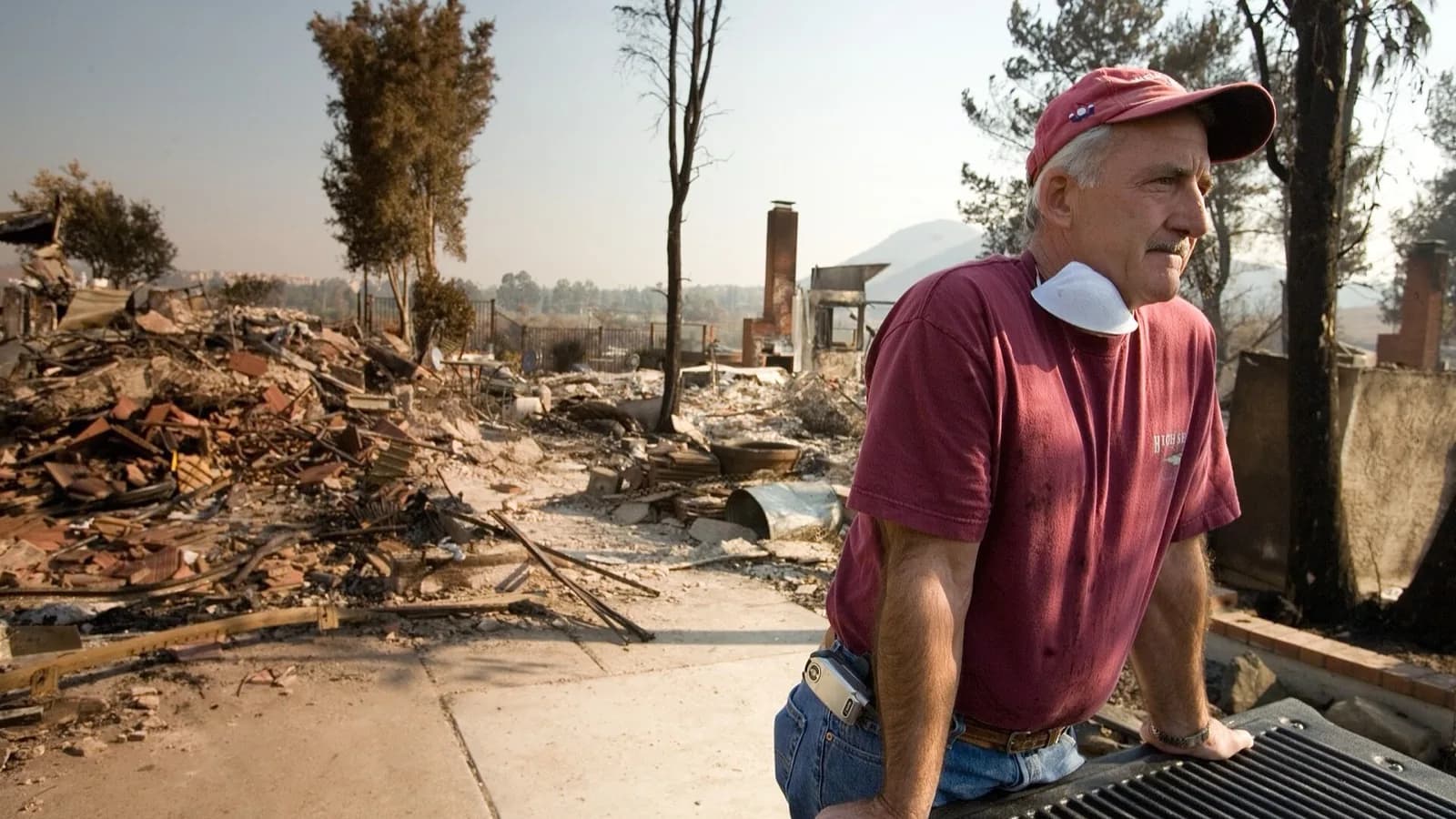 A homeowner stands amid the burned ruins of a California house destroyed by wildfire.