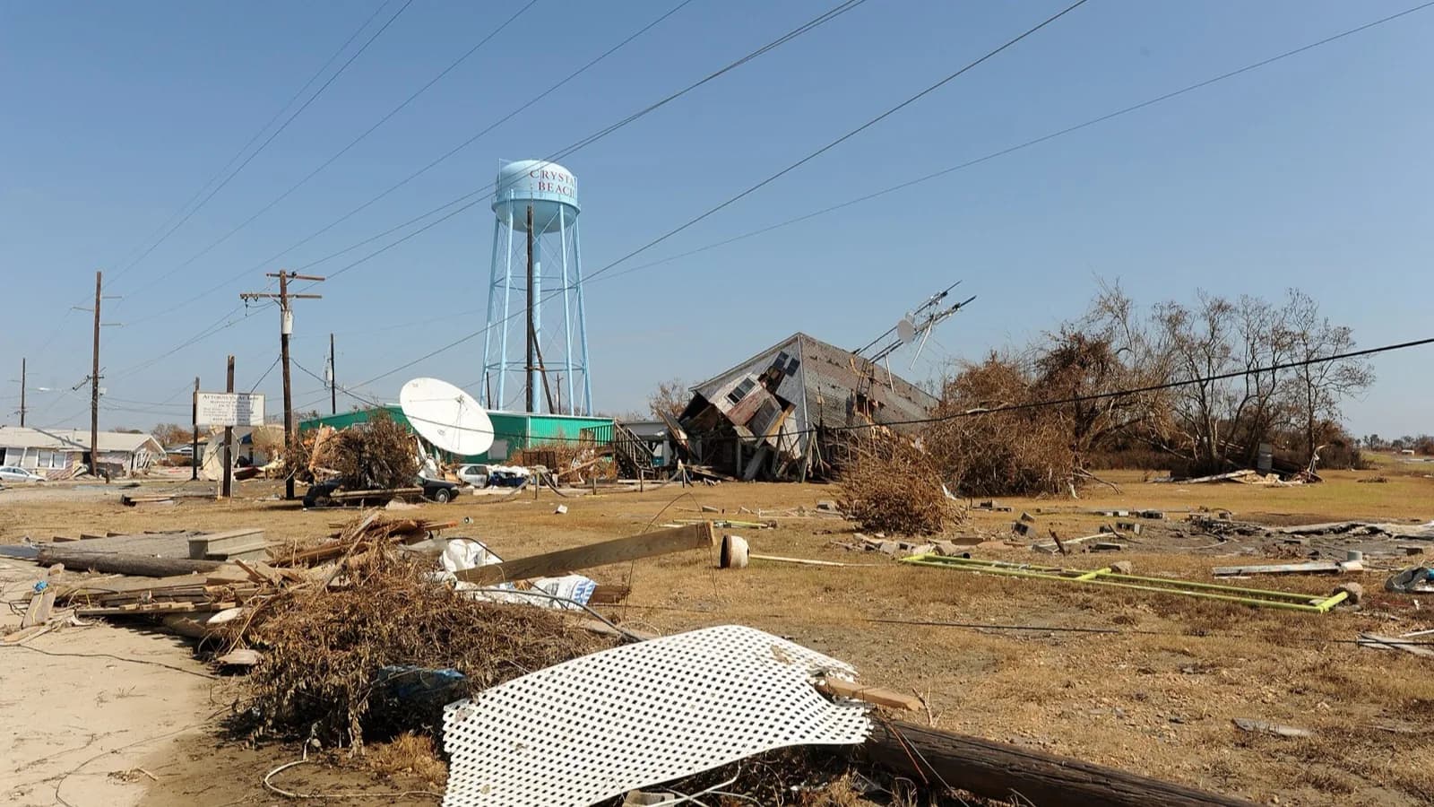 A coastal neighborhood flattened by a hurricane, a lone water tower standing over the debris field.