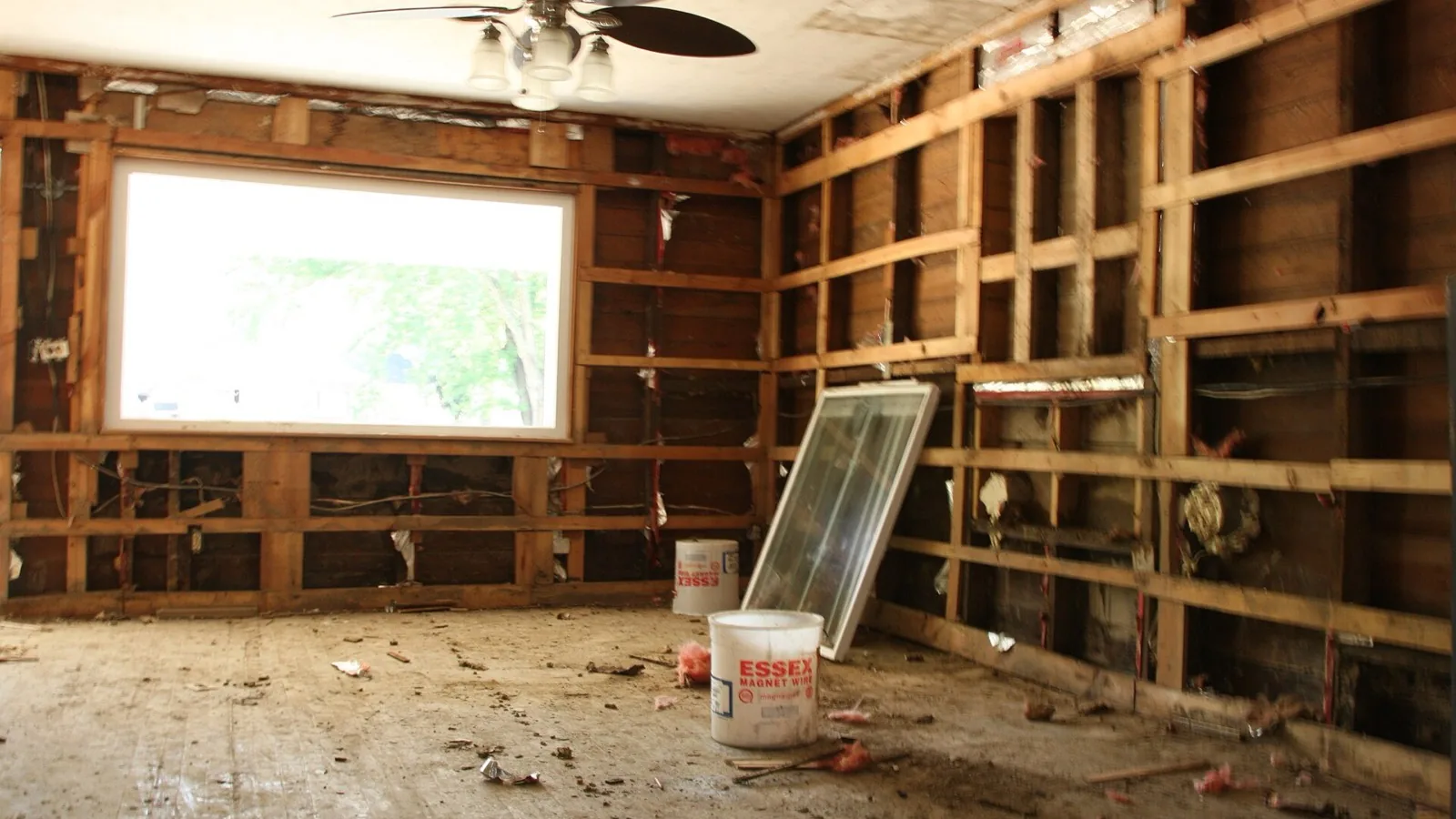 A flood-damaged room stripped back to the wall studs during water mitigation.